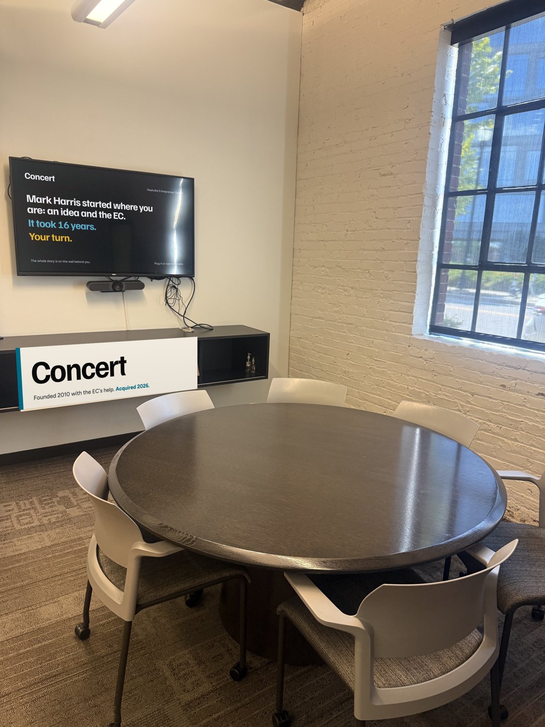 TV showing the Concert idle screen above a credenza sign reading Concert.